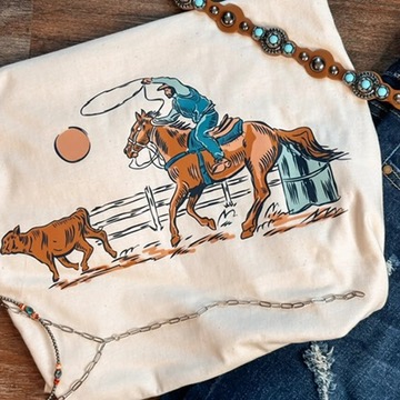 Beige Roundup graphic T-shirt featuring a colorful cowboy riding a horse and roping a calf.